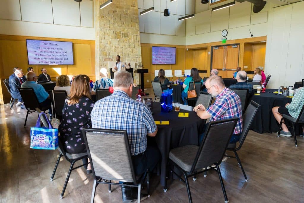 Seminar guests seated at tables listening to a presentation